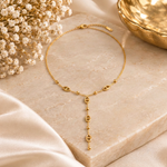 Collier Tania avec boules dorées sur décor beige