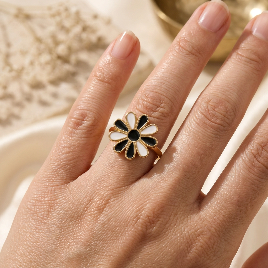 Bague Marguerite noire portée au doigt en gros plan